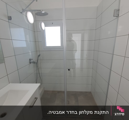 מקלחון זכוכית עם ראש מקלחת עגול וקירות לבנים